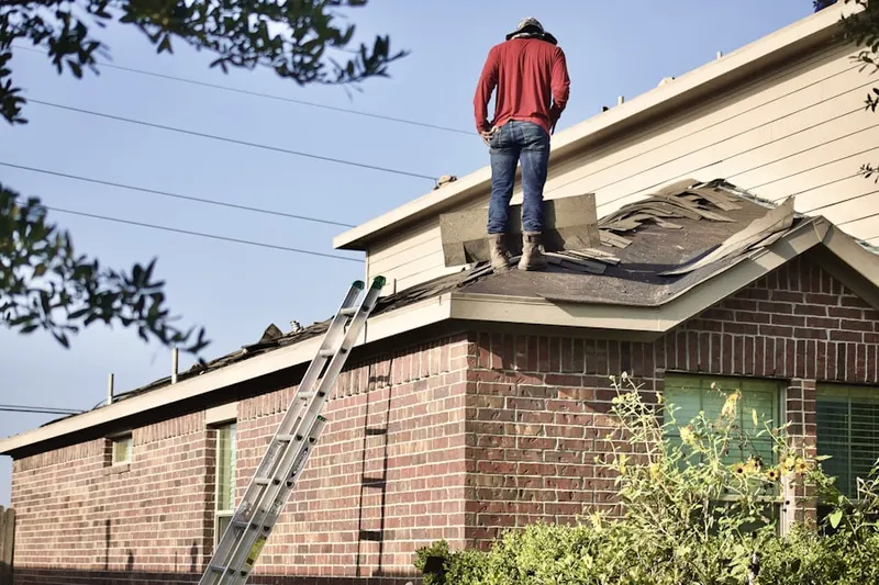Professional roofer working on a residential roof in East Utica